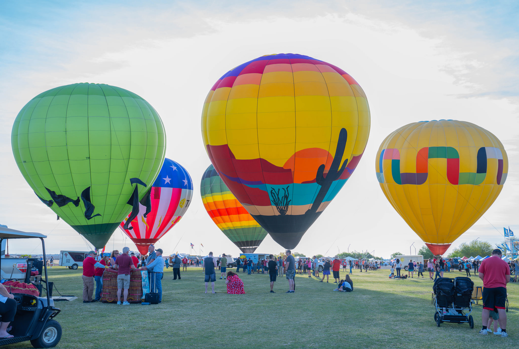Colorful hot air balloons at the Arizona Balloon Classic, with attendees enjoying the event at Wild Horse Pass Festival Grounds in Chandler, AZ.