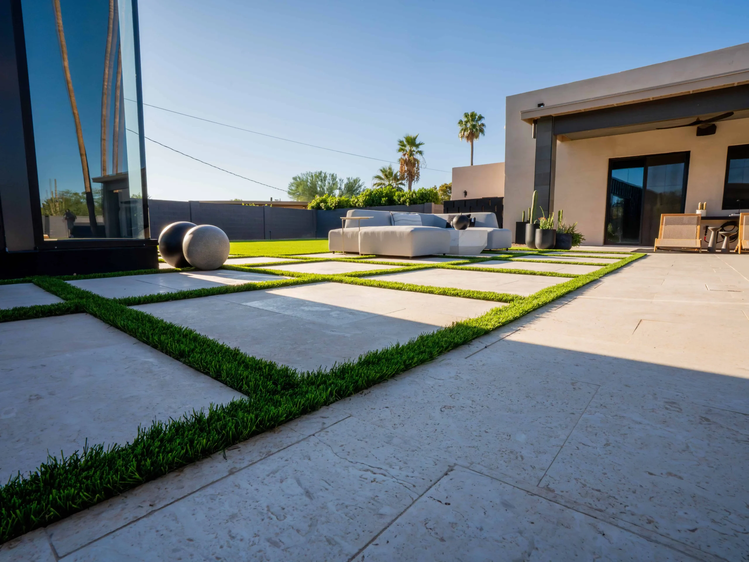 Artificial turf bordered by a paver patio at a San Antonio, TX backyard